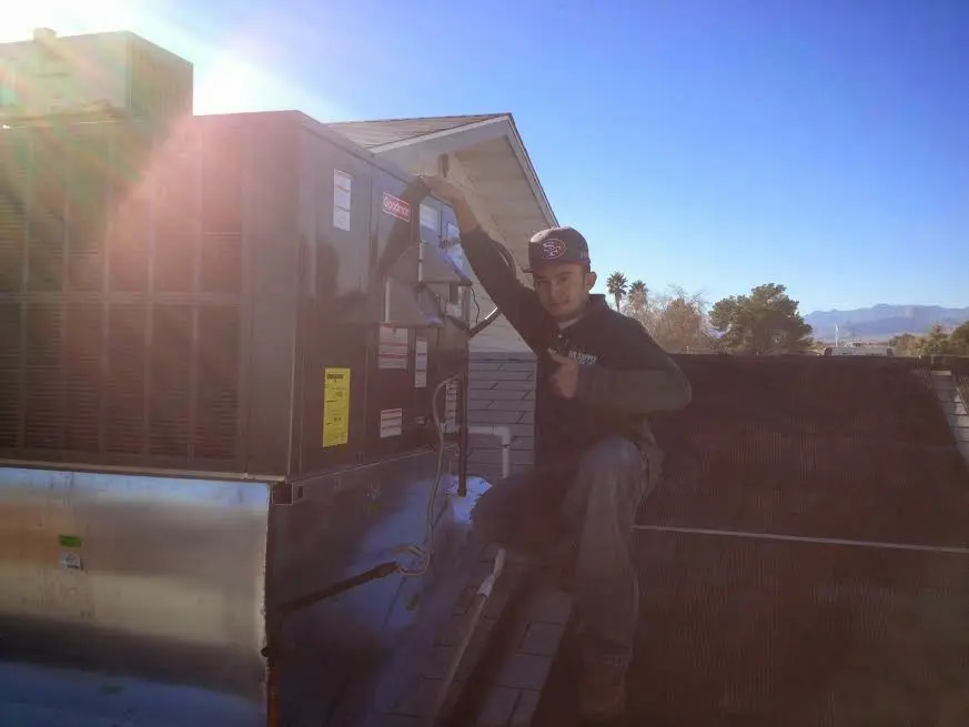 HVAC technician performing Heat Pump Repair on a rooftop unit in Paris